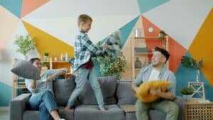 a mother and father have a pillow fight on a couch with their song